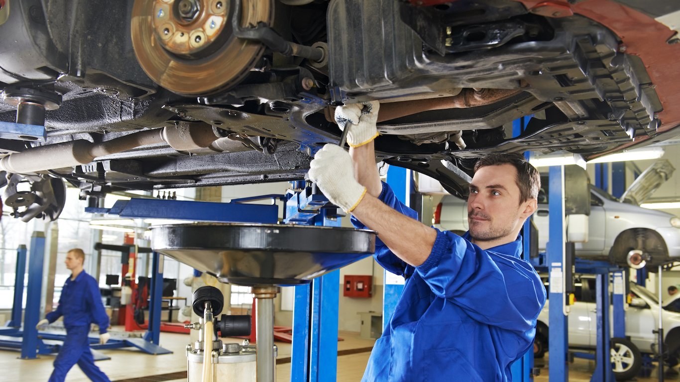 An auto mechanic repairing the suspension on a car