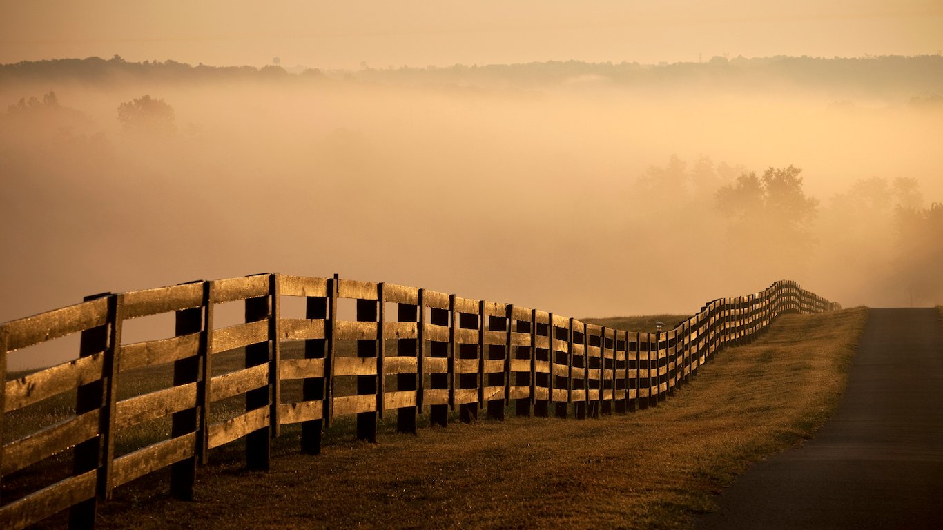 Farm Fence and road at sunrise with fog, Kentucky