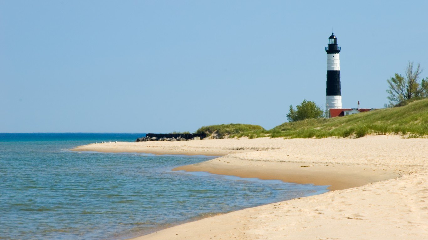 Lighthouse overlooking the beach, water, and sand along the shore of Lake Michigan, "Big Sable" light in Ludington, MI, USA.