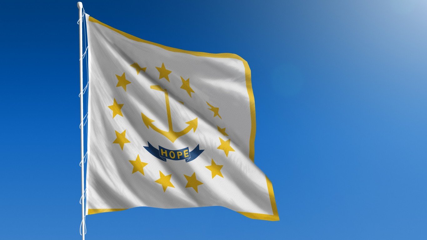 The flag of the state of Rhode Island blowing in the wind in front of a clear blue sky