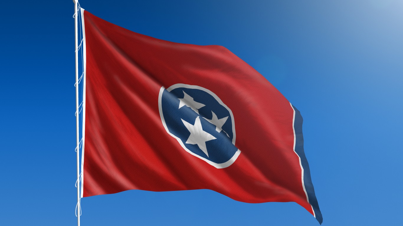 The flag of the state of Tennessee blowing in the wind in front of a clear blue sky