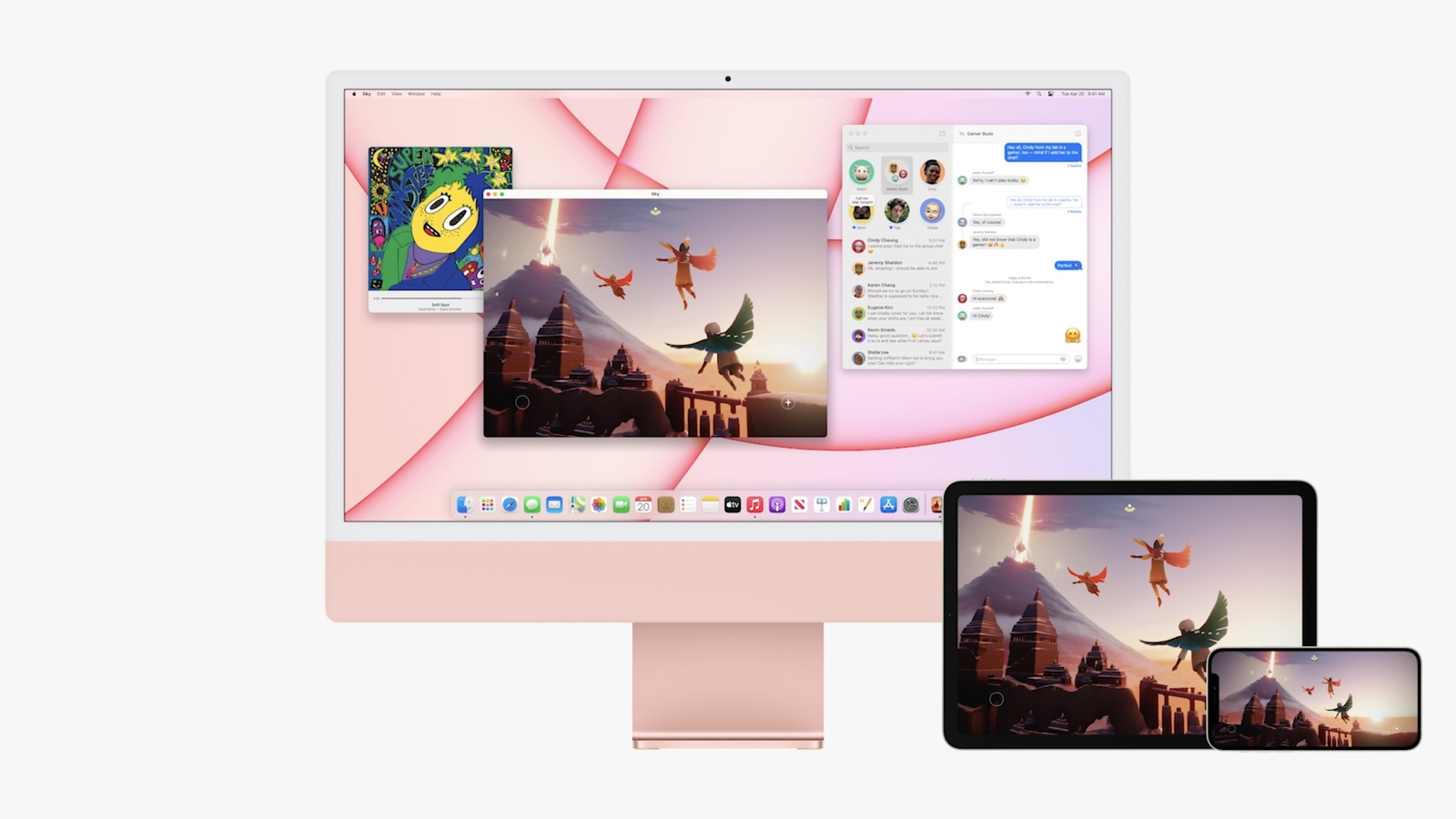 An eye-level shot shows a pink Apple iMac on a white surface, displaying multiple open windows: a colorful music player, a vibrant game with flying characters and ancient buildings, and a messaging app. To the right, an iPad and iPhone also display the same game, emphasizing device integration.