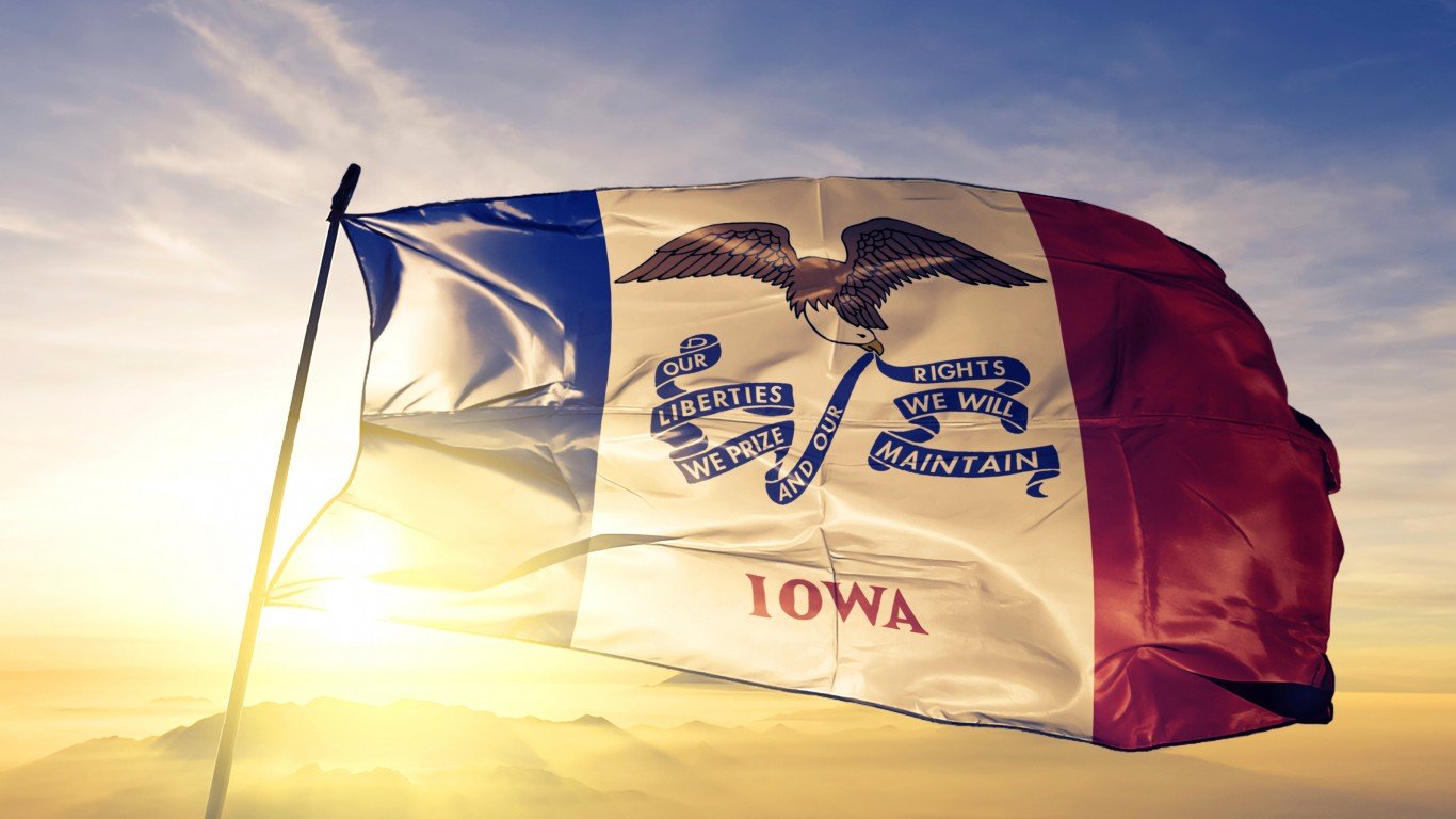 Iowa state of United States flag on flagpole textile cloth fabric waving on the top sunrise mist fog