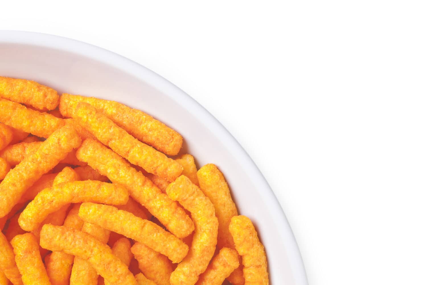 Cropped image of bowl of cheese puffs against white background
