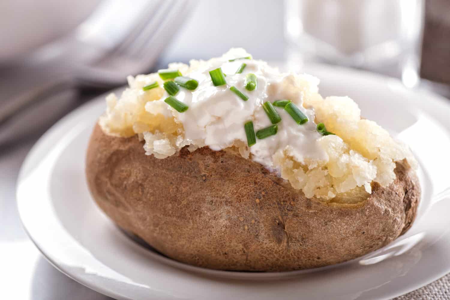 A delicious oven baked potato with sour cream and chives.