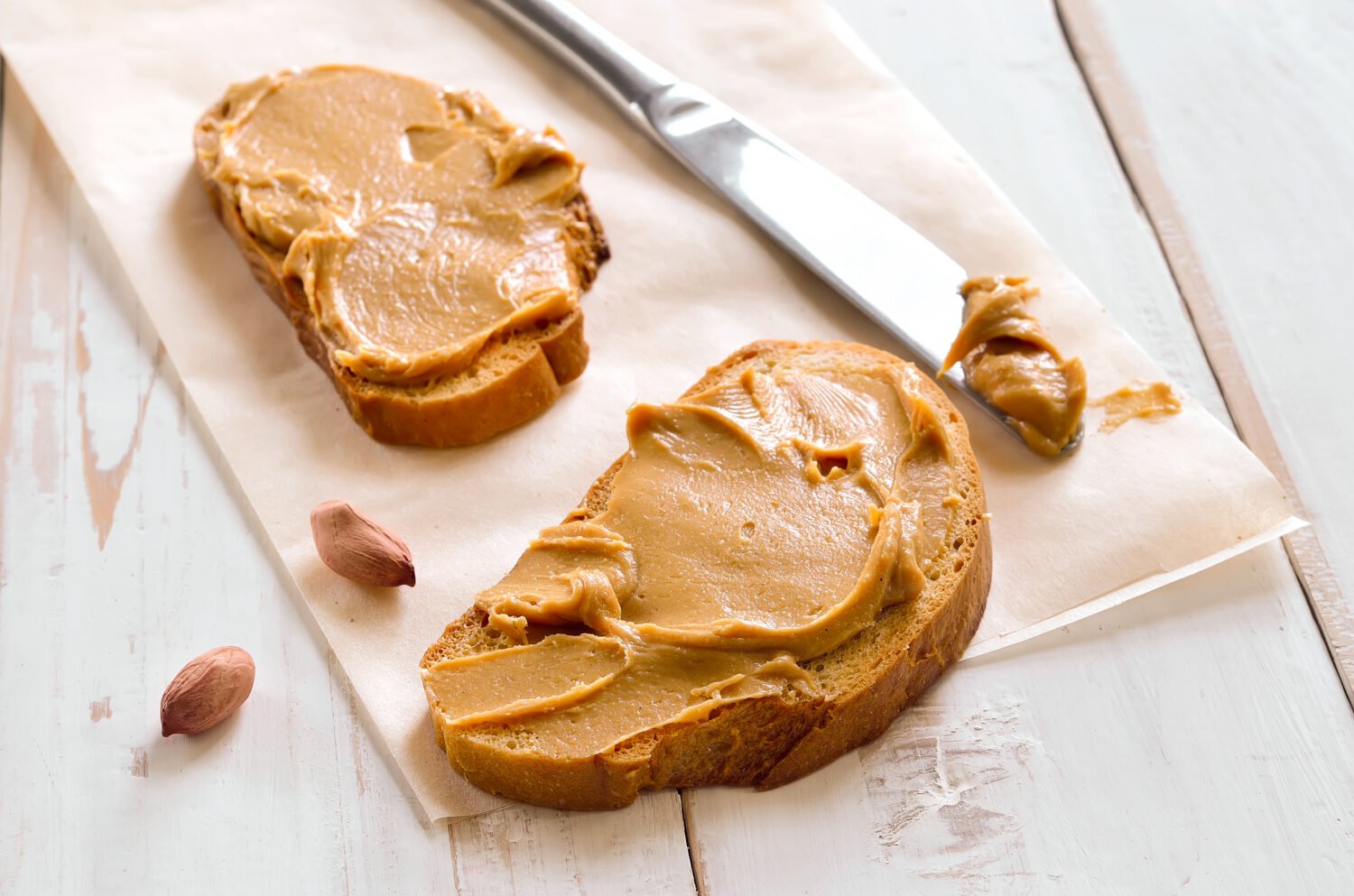 Peanut butter sandwiches or toasts on light wooden background