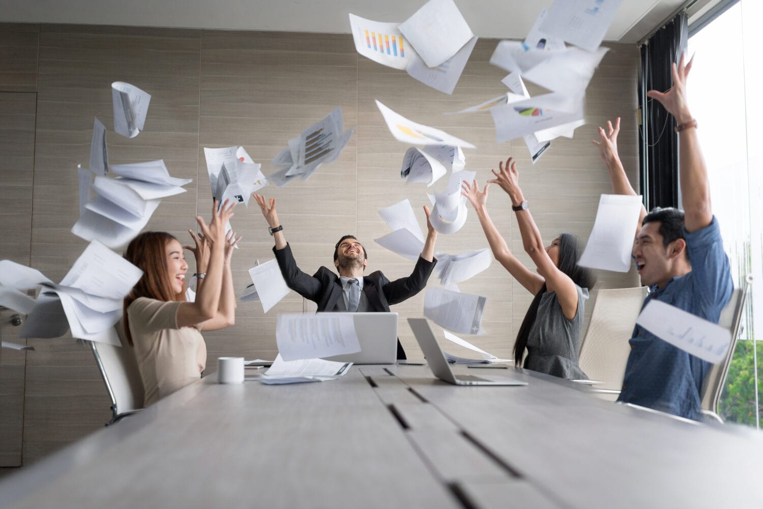 Teamwork business people excited happy smile, throw papers and documents fly in air. Success team concept after sign contract.In selective focus and motion blur moving with perspective view.
