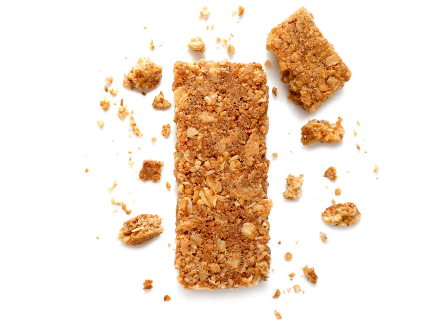 Cereal bars or flapjacks made from rolled oats with crumbs isolated on white background. Top view.