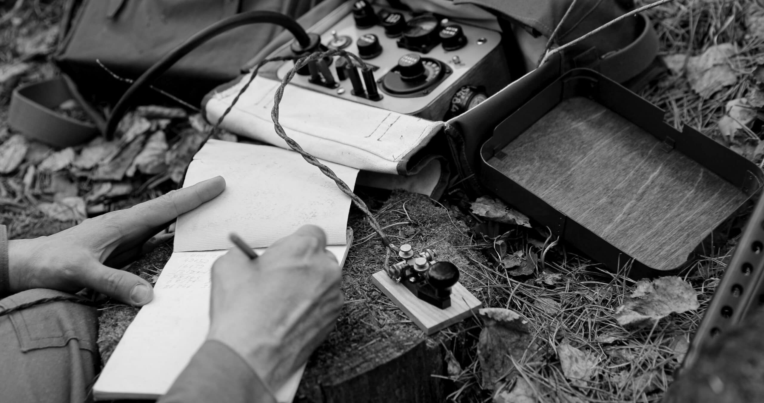 Infantry Army Soldier In World War II using Portable Radio Transceiver In Trench Entrenchment In Forest. . Headphones And Telegraph Key. Close Up Hands, Black And White Colors