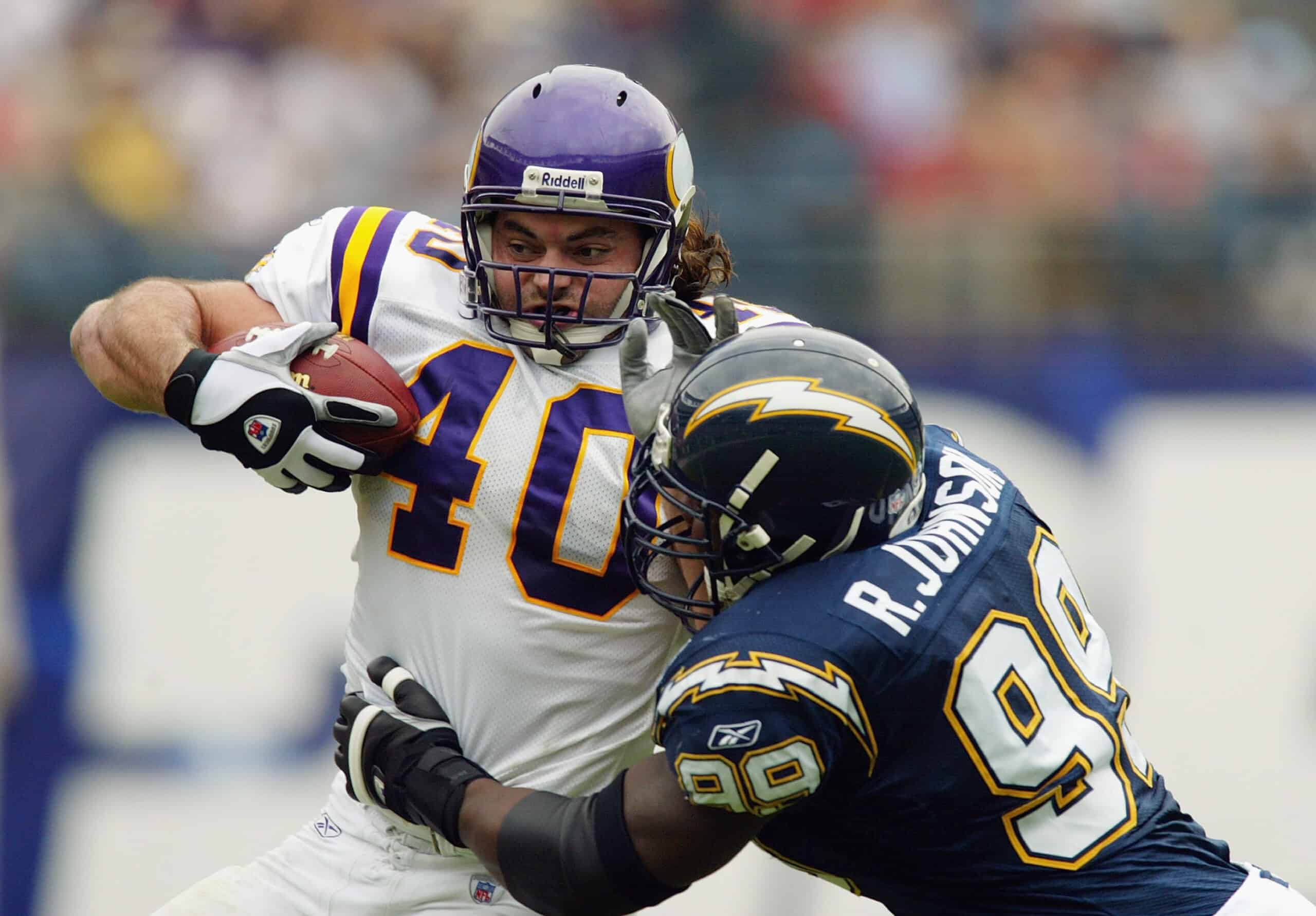 SAN DIEGO - NOVEMBER 9: Jim Kleinsasser #40 of the Minnesota Vikings carries the ball against Raylee Johnson #99 of the San Diego Chargers on November 9, 2003 at Qualcomm Stadium in San Diego, California. The Chargers defeated the Vikings 42-28. (Photo by Donald Miralle/Getty Images)