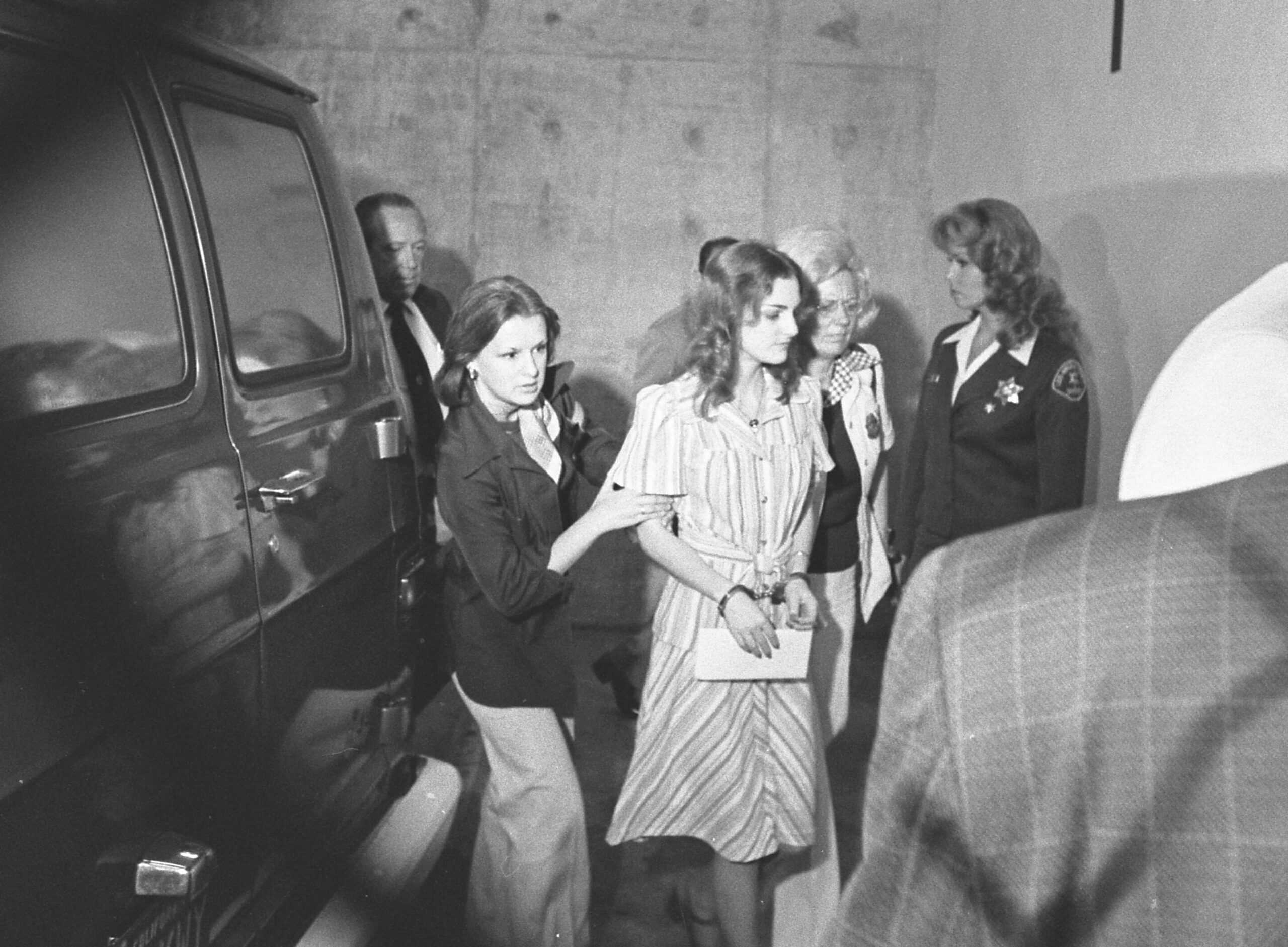 Patty Hearst is escorted by marshals into a Los Angeles courthouse for a pretrial hearing for the 1974 shootout at Mel's Sporting Goods in Inglewood.