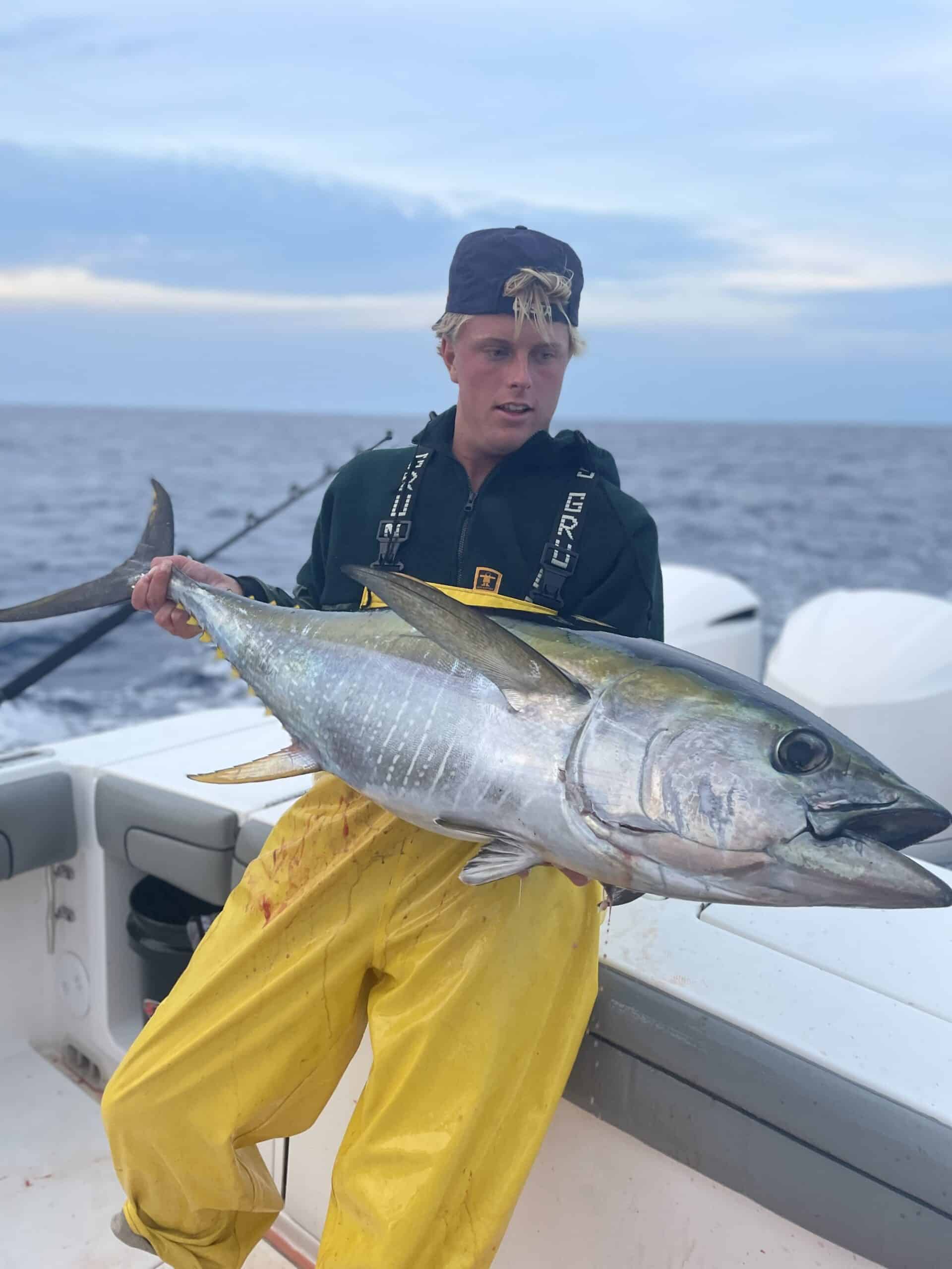 Fisherman holding yellowfin tuna by Finleybailis