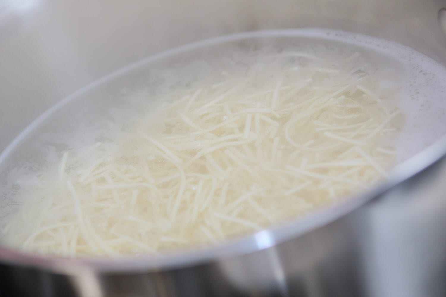 Cooking pasta. Close up view of boiling instant noodles in the pot.