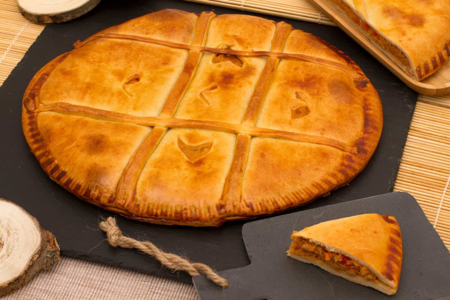 Round galician pie of bread dough on slate plate - Empanada gallega (Galicia . Spain)