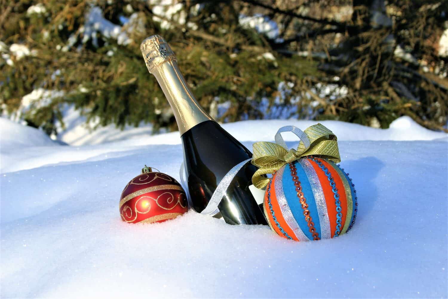Sparkling wine and Christmas decorations on white snow