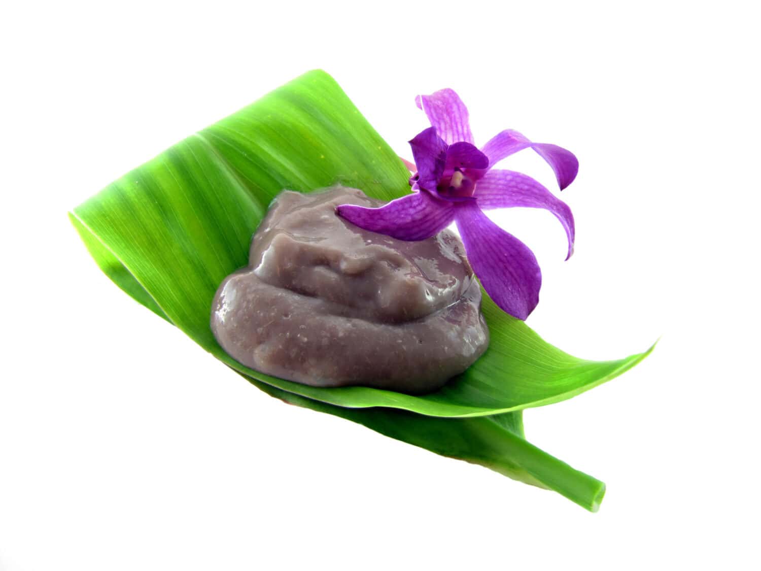 Poi on a tea leaf with an orchid isolated on white. A popular food in Hawaii made with taro, typically eaten by scooping with two fingers.