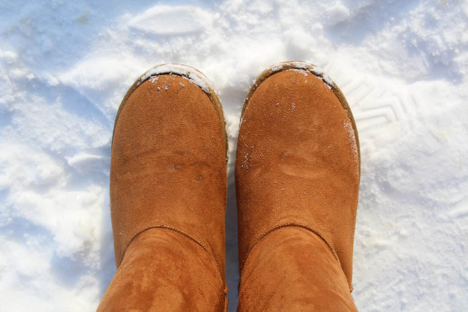 warm brown ugg boots on snow in cold winter