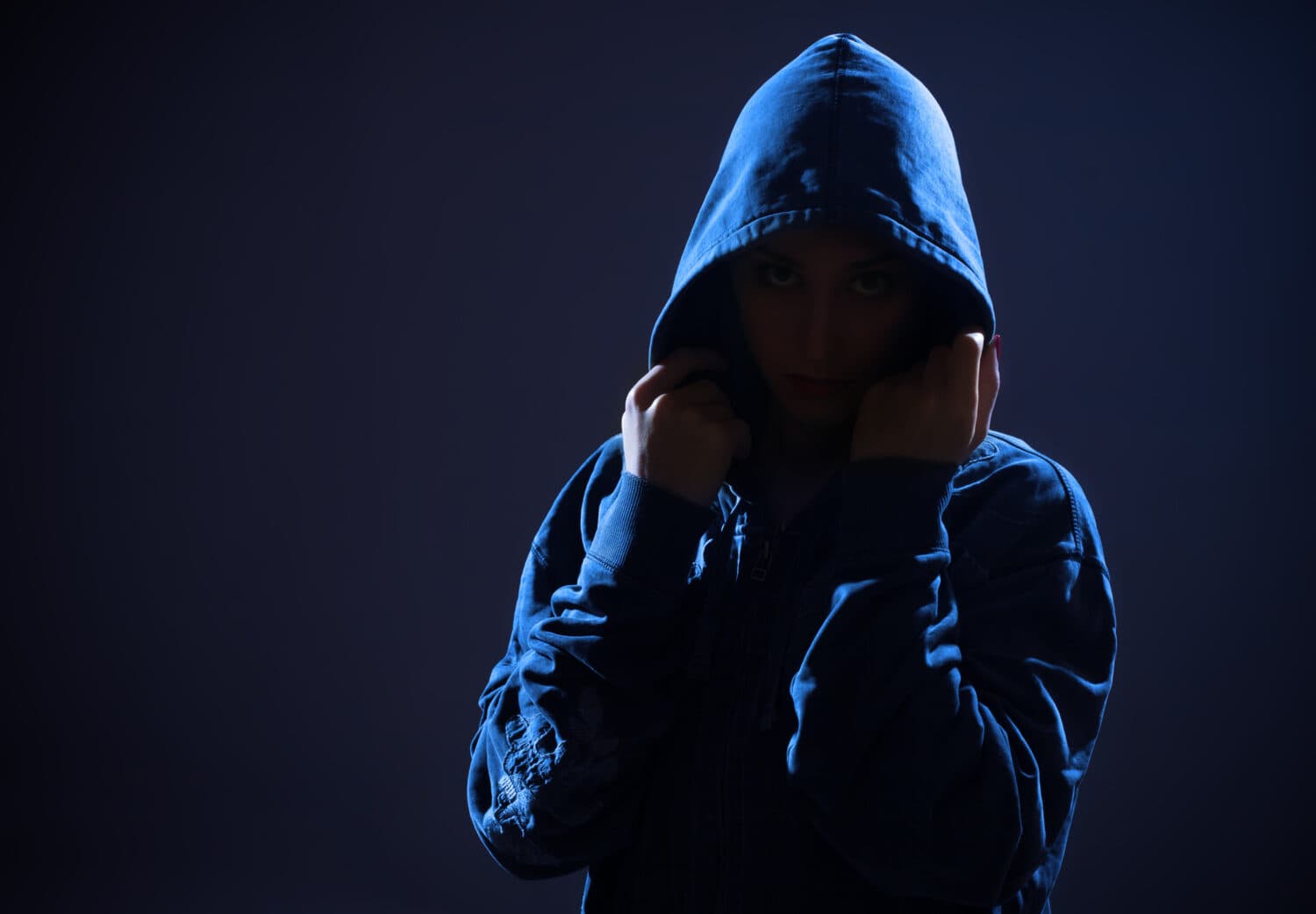 woman with hood in darkness