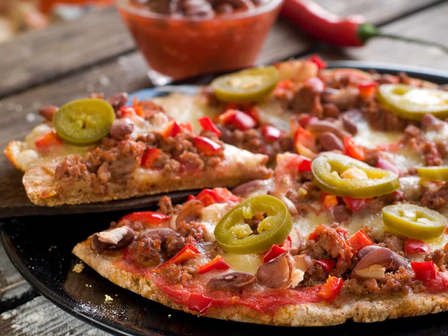 Mexican pizza with minced bean, bean and jalapeno, selective focus