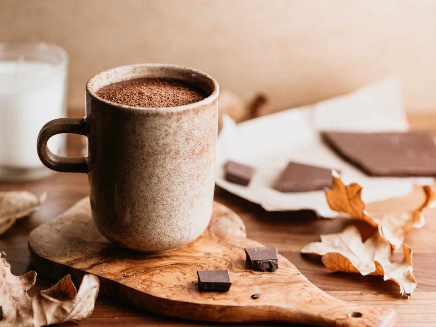 Close-up of hot chocolate in a ceramic mug on the table. Autumn or winter cozy still life.