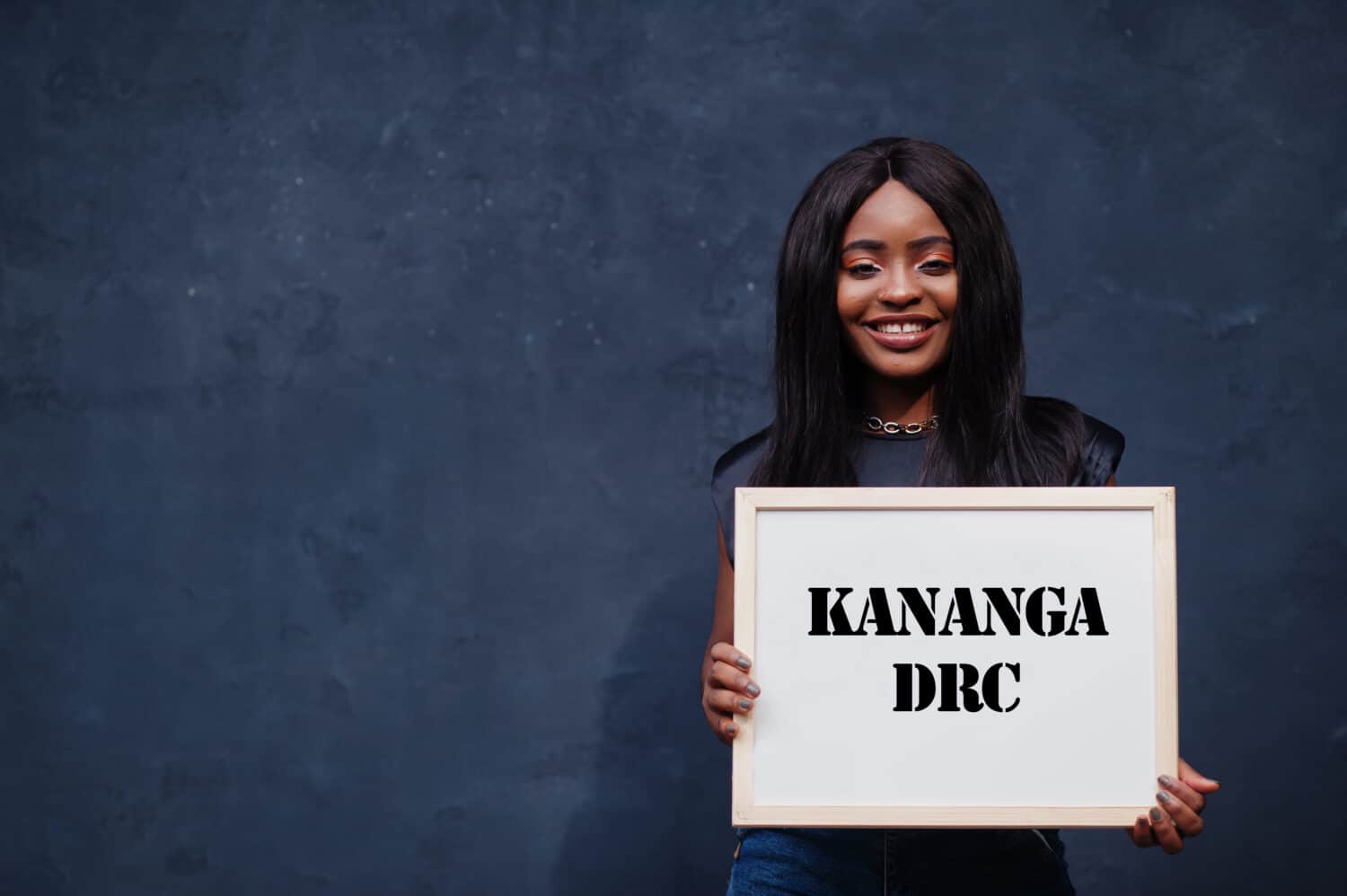 African woman hold white board with Kananga DRC inscription. Most populous city in Africa concept.