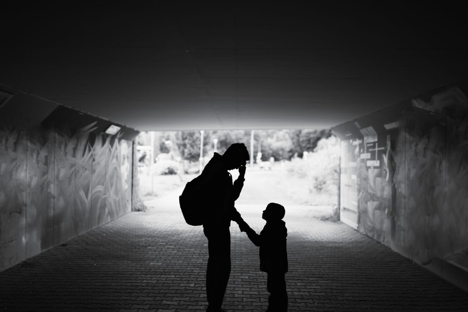 Tired , sad, stressed single father parent taking care of child standing in a dark city street. Family hardship, problems