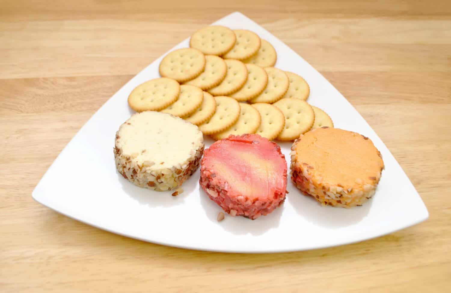 Cheddar Cheese Log Slices on a Plate with Round Crackers