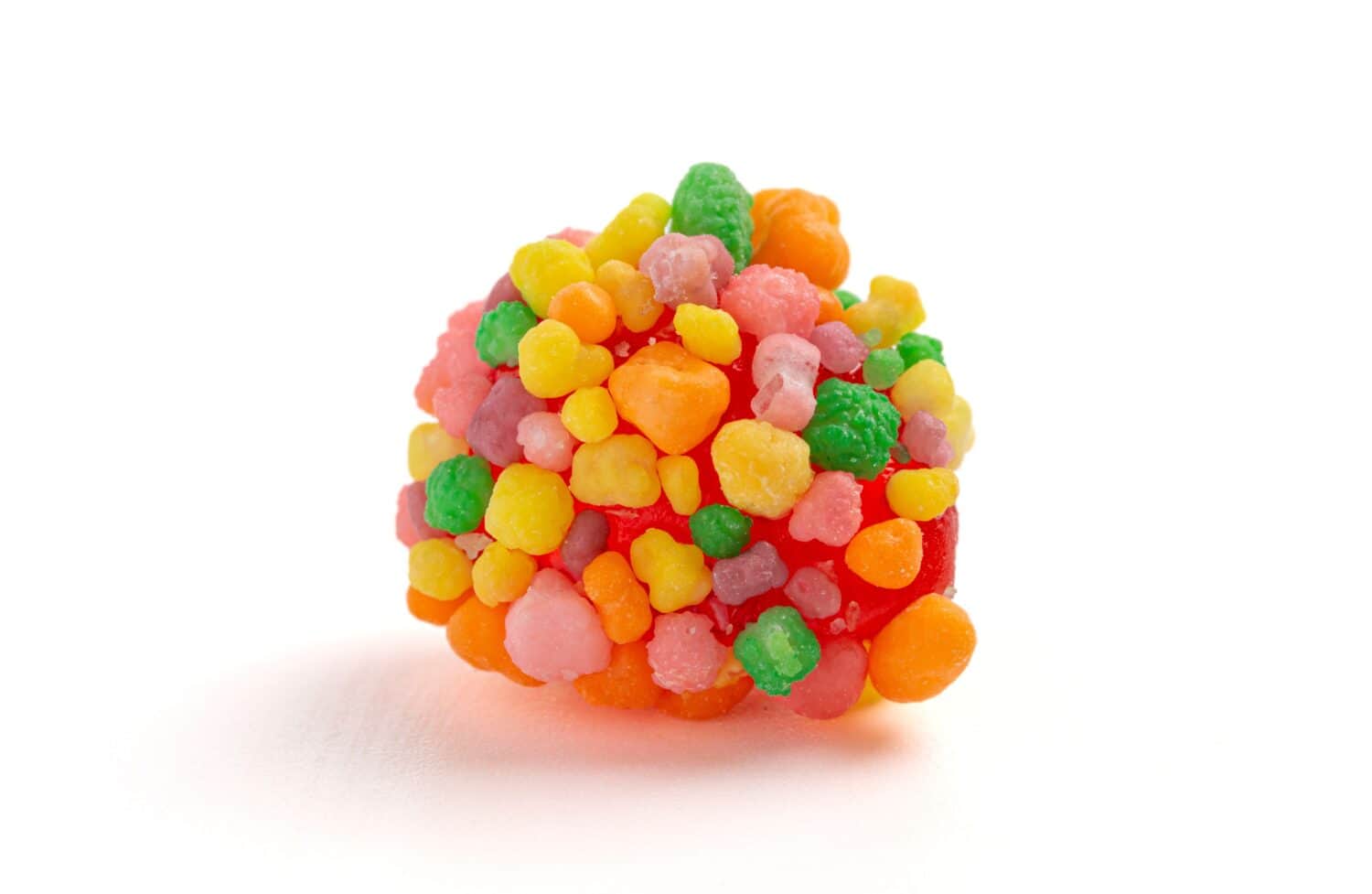A Sweet and Tangy Candy with Small Candies on the Outside of a Chewy Center on a White Background