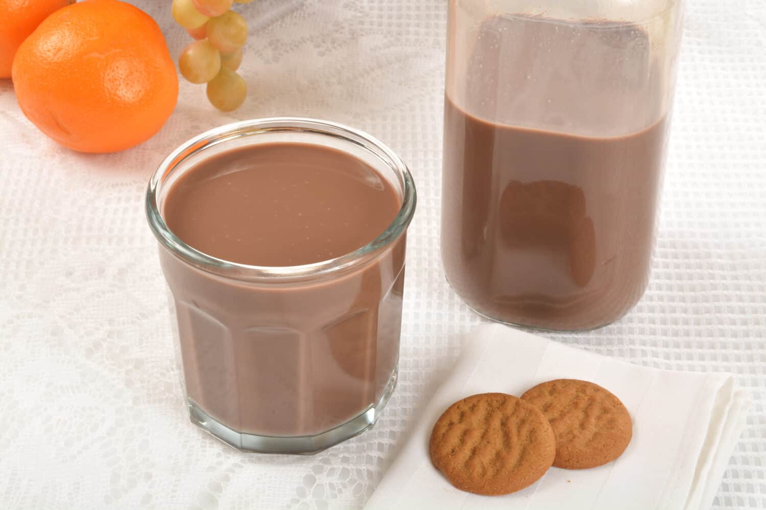 A glass of chocolate milk and ginger snap cookies
