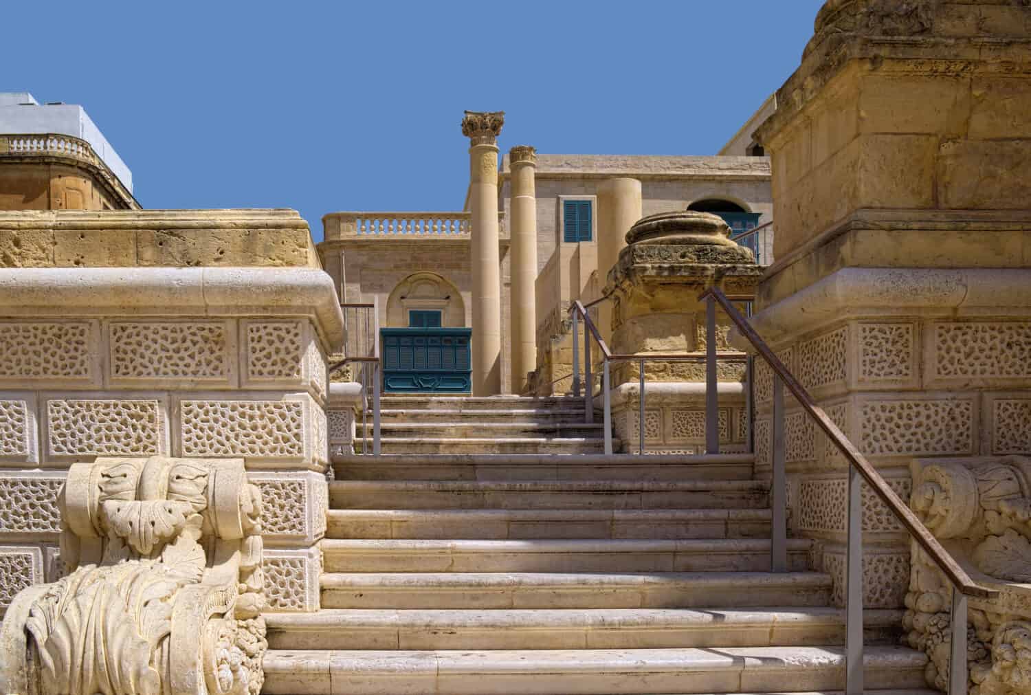 Stone staircase, columns and other architectural fragments of ruined Royal Opera House in the historic part of Valletta, Malta. All stones has typical Maltese yellowish coloring.