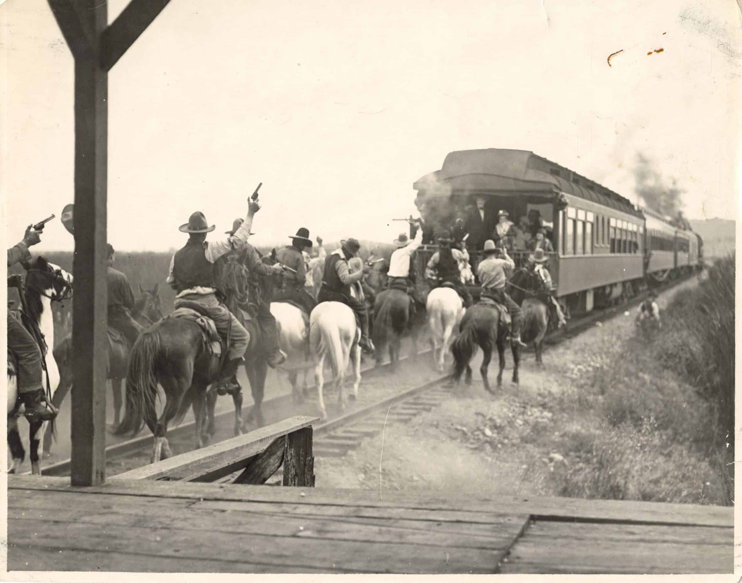 Cowboys riding behind train