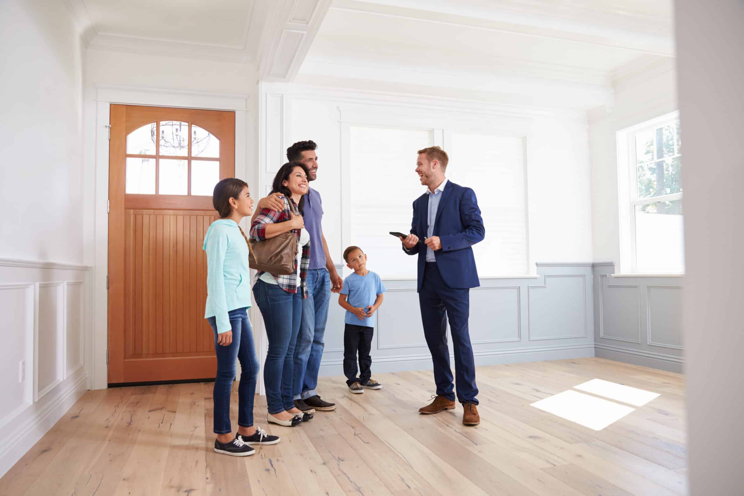 Real Estate Agent Showing Hispanic Family Around New Home
