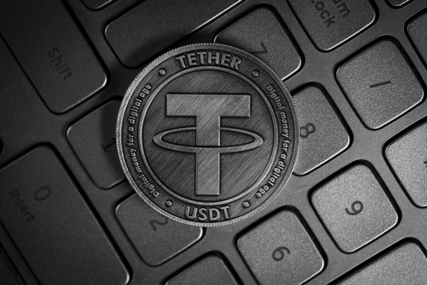 Tether USDT Cryptocurrency physical coin placed on computer keyboard