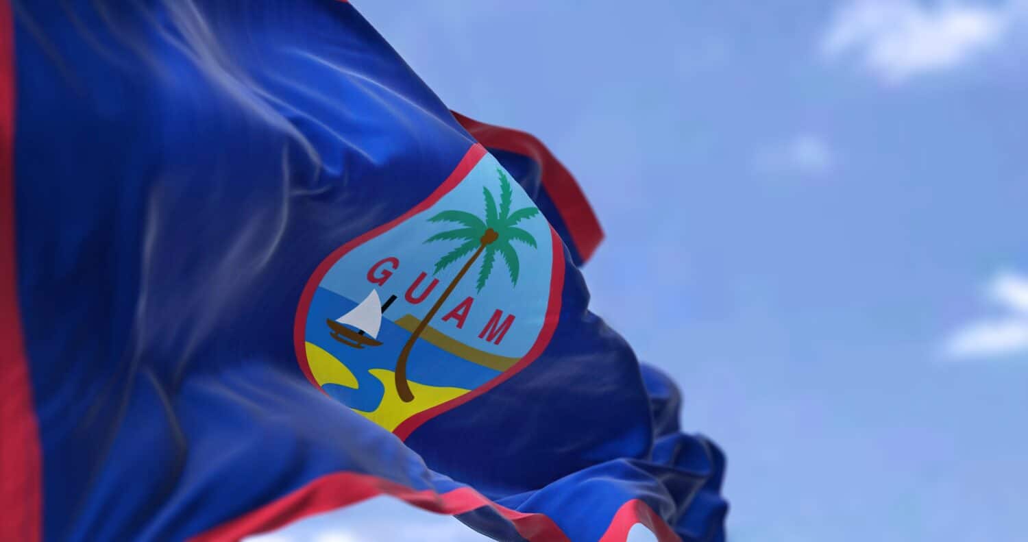 Flag of Guam waving in the wind on a clear day. Guam is an organized, unincorporated territory of the United States in the Micronesia subregion of the western Pacific Ocean