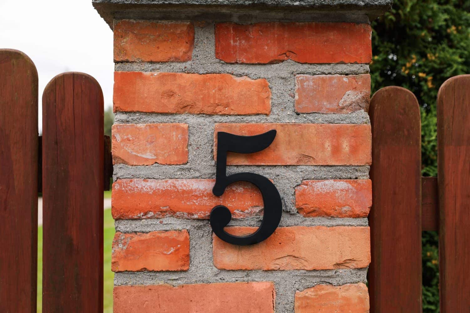 House number 5 on red brick column outdoors