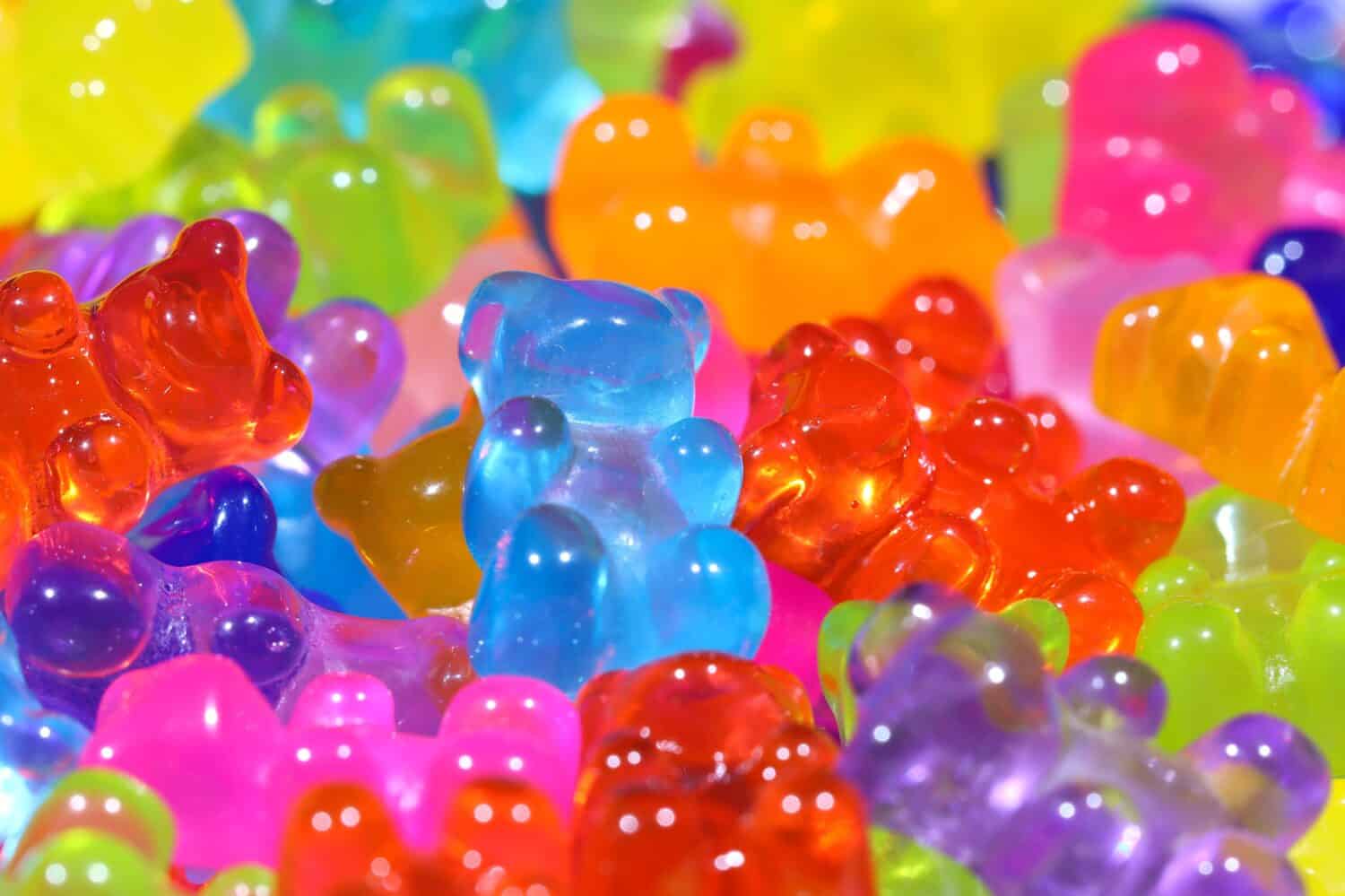 Pile of brightly lit gummy bear sweets. Shallow depth of field, central focus.
