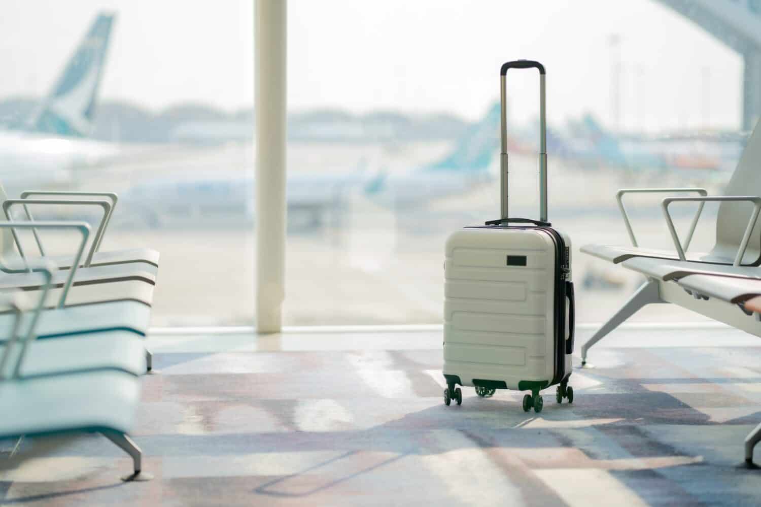 The suitcases in an empty airport hall, traveler cases in the departure airport terminal waiting for the area, vacation concept, blank space for text message or design
