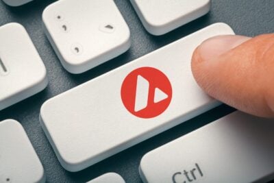 Cryptocurrency trading or exchange concept: Male hand index finger pressing computer key with Avalanche token logo.