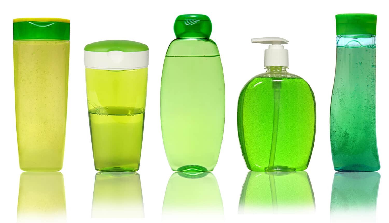 Five Green Plastic Bottles With Shampoo, Liquid Soap, Shower Gel. Isolated on white background with reflection.
