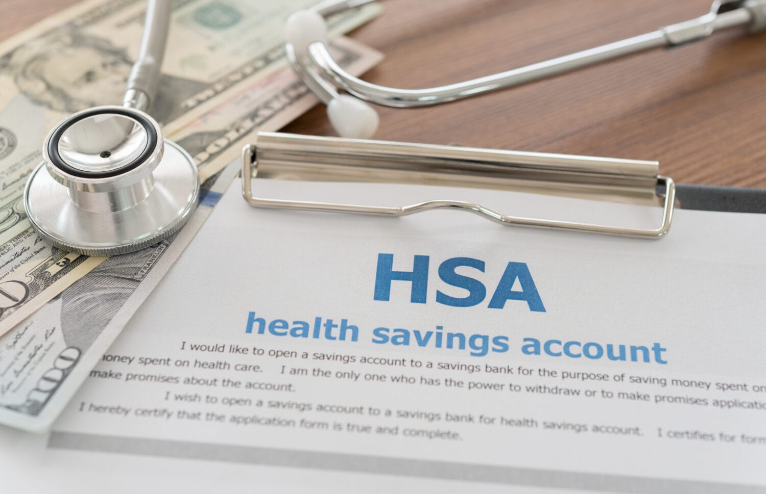 health savings account HSA concept with application form,dollar money, stethoscope on desk.