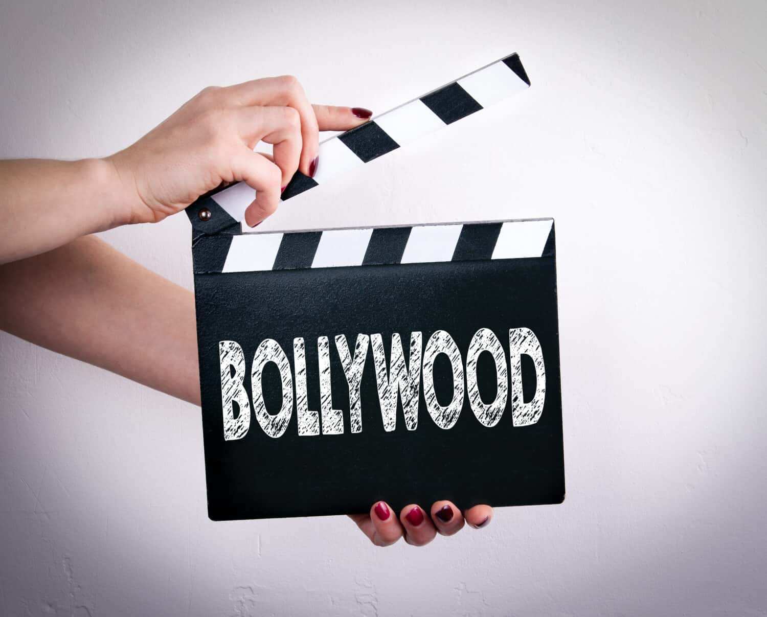 Bollywood. Female hands holding movie clapper