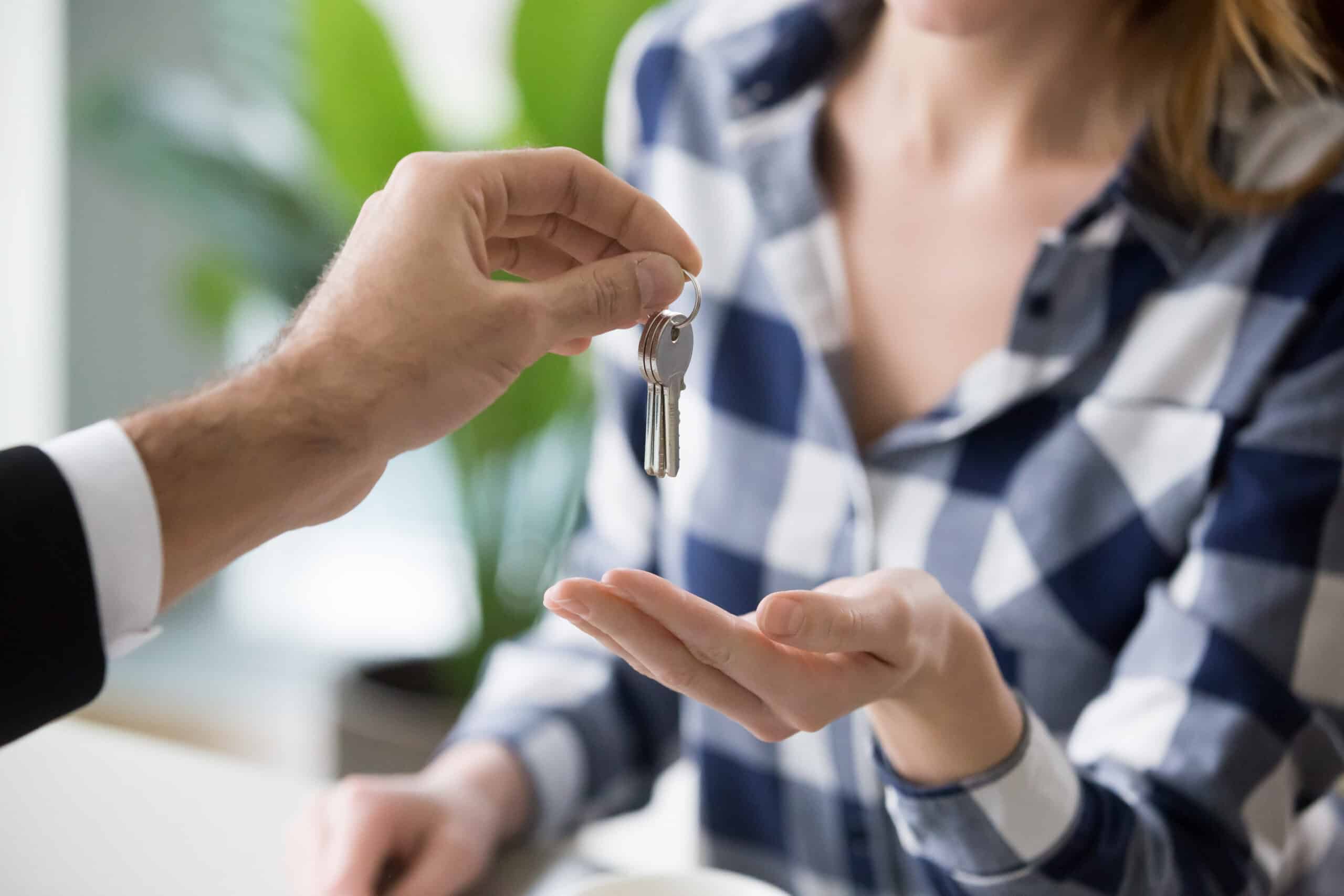 Young woman getting keys to new apartment from Real Estate Agent
