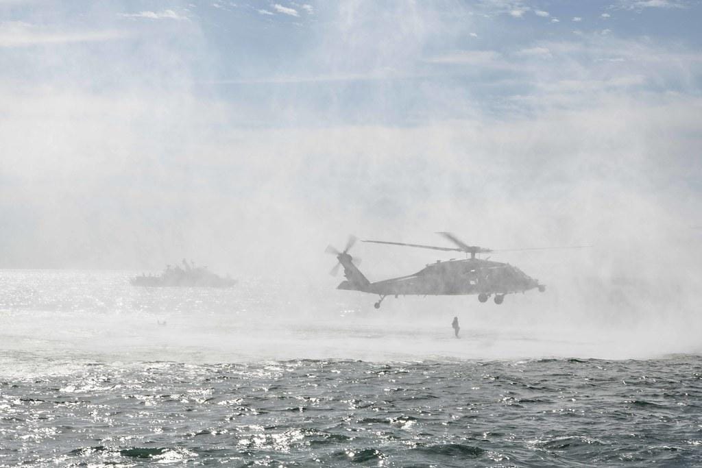 An MH-60S Sea Hawk helicopter participates in a floating mine response training exercise with a Mark VI patrol boat in the Arabian Gulf. by Official U.S. Navy Imagery