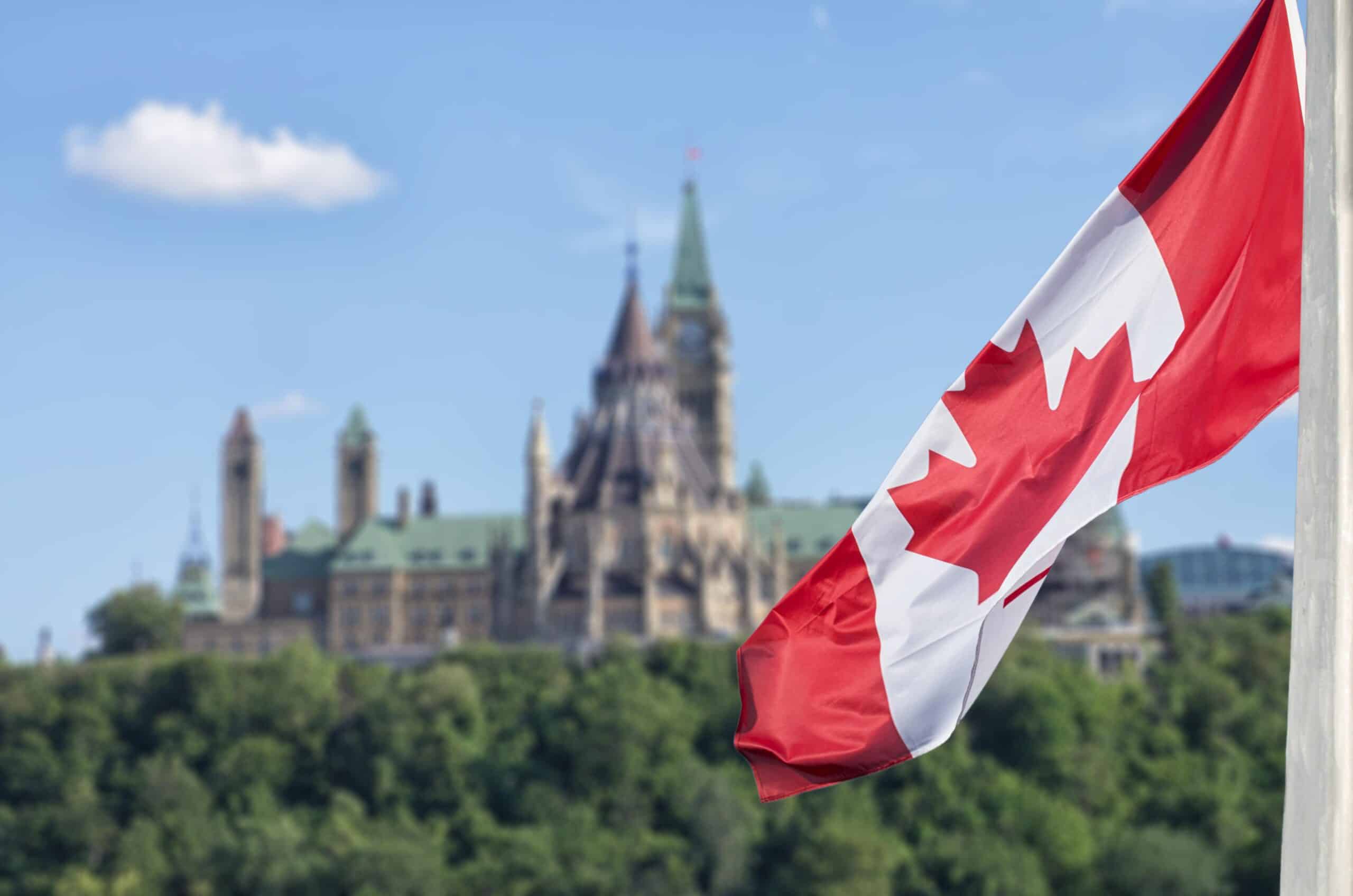 Canada | Canadian flag waving with Parliament Buildings hill and Library