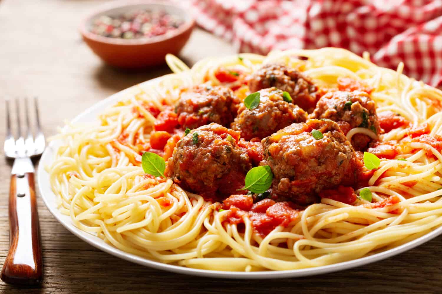 plate of pasta with meatballs on a wooden table