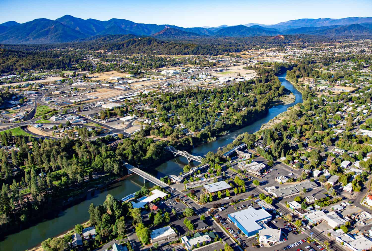 Aerial view of downtown Grants Pass with the Caveman concrete arch bridge and the 7th street bridge crossing the Rogue River