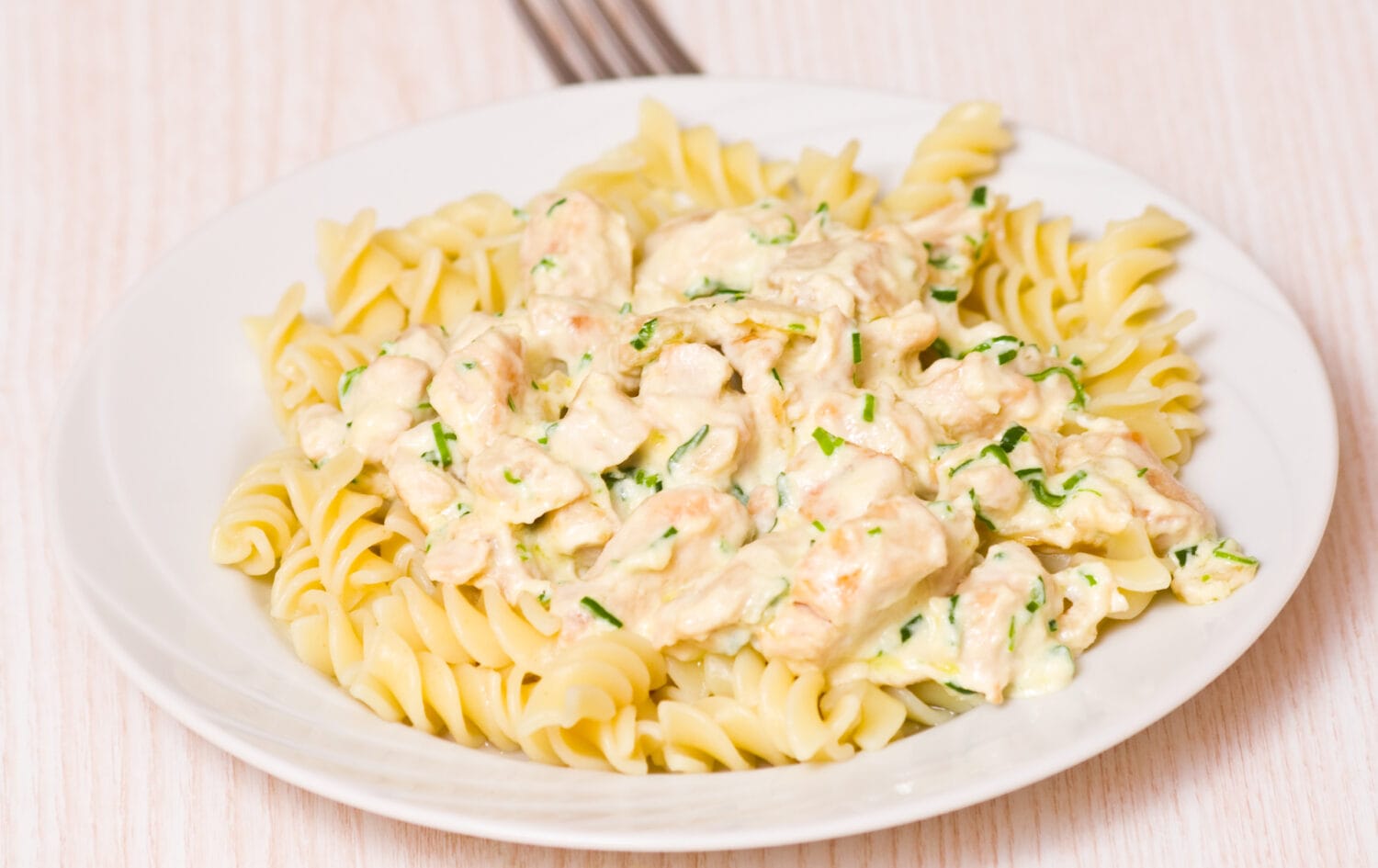 Sliced fried chicken fillet with garlic and rosemary in a creamy sauce. with fusilli pasta
