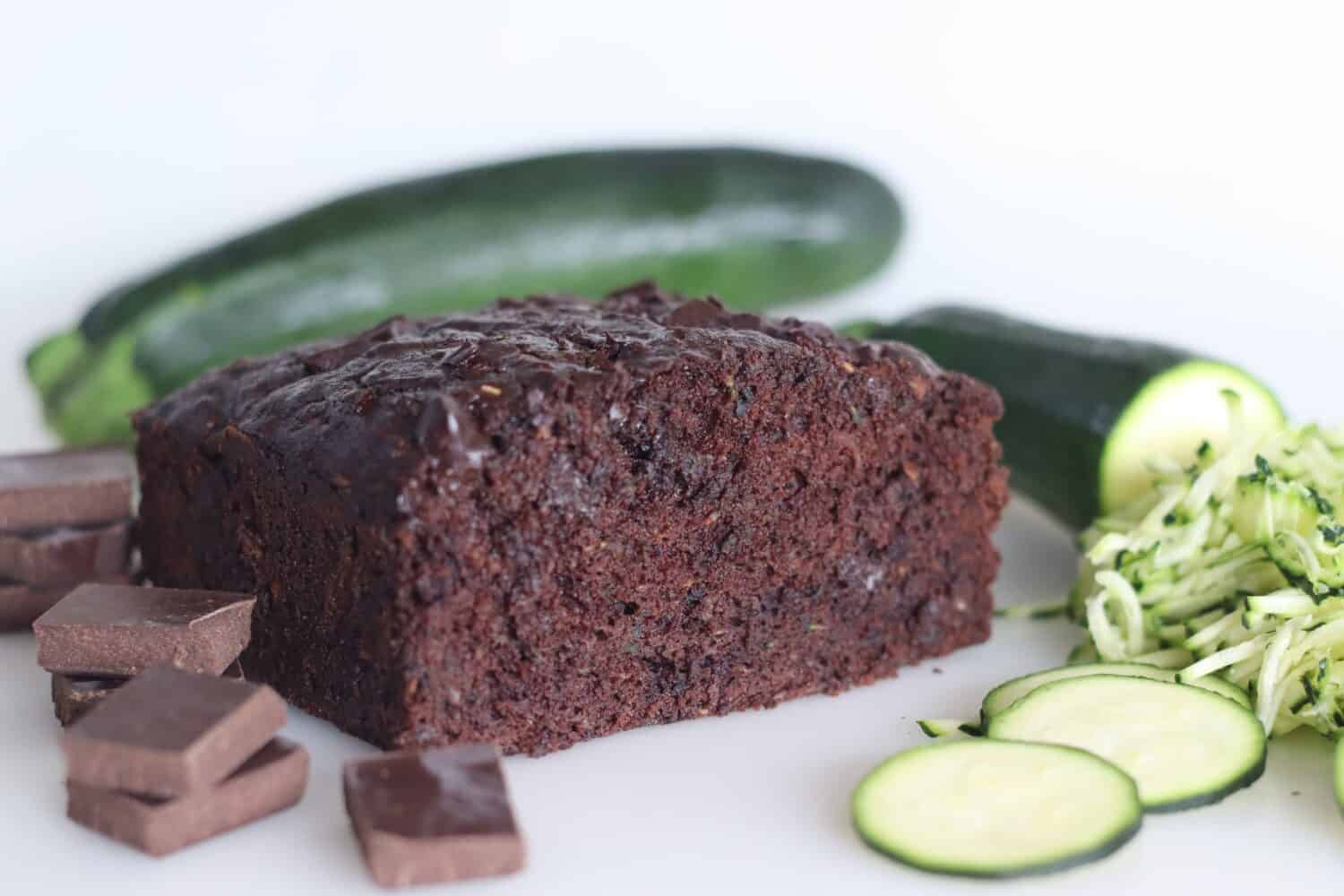 Zucchini chocolate cake. Moist double chocolate cake with grated zucchini, coco powder, chocolate and chocolate chips. Shot on white background