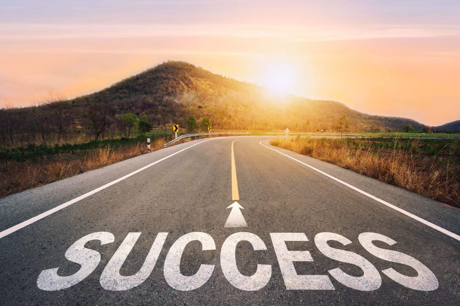Success written on asphalt road in sunset concept of goals and challenges or career path success business opportunity and change.