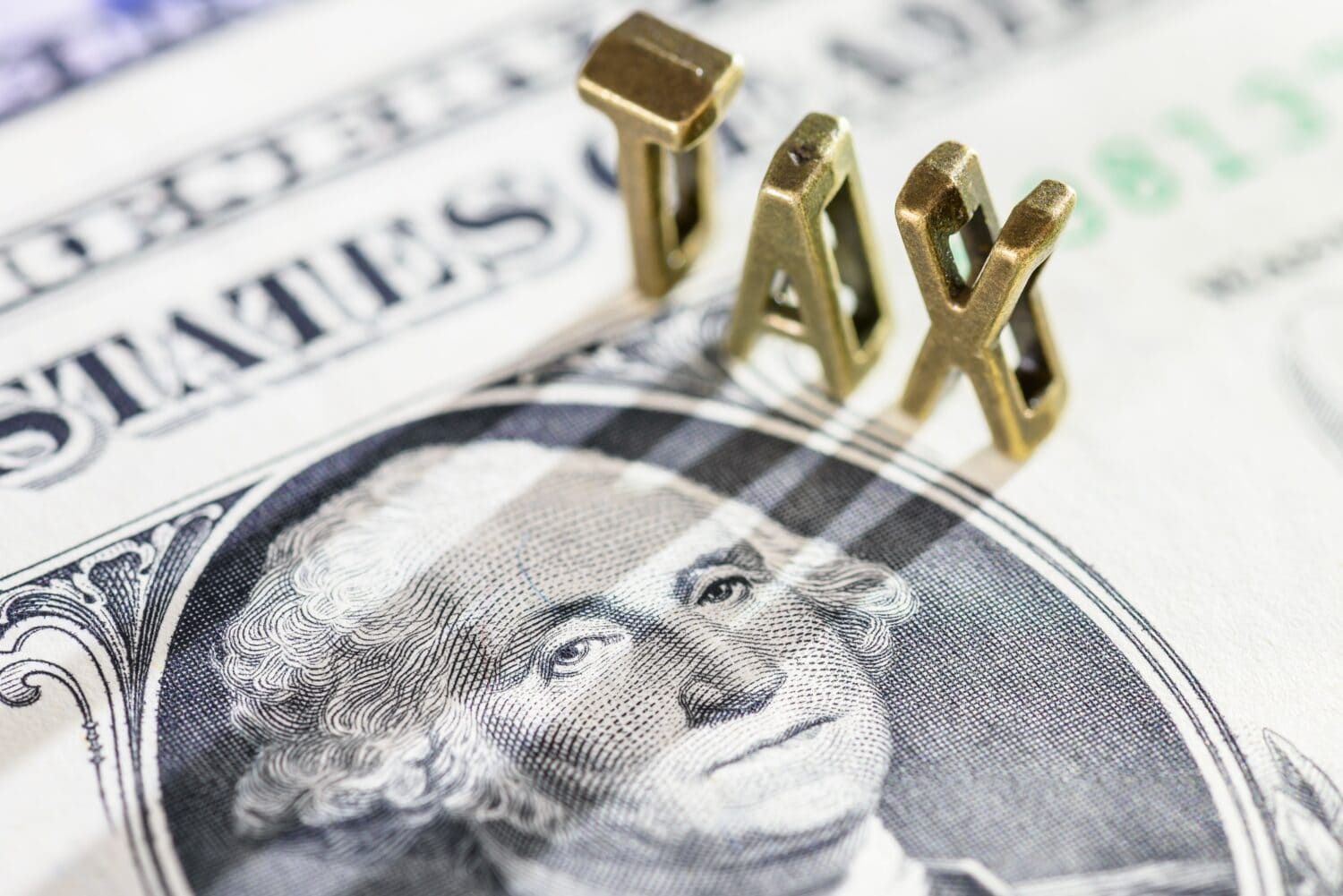 Income tax, tax collection, financial concept : The word tax with a photo of US President George Washington on a one-dollar bill. Tax is a Compulsory payment to government based on income or wealth.
